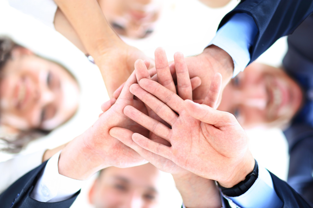 Small group of business people joining hands